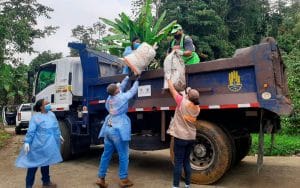 Un grupo de personas cargando un camión con plátanos en casa.